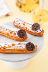 Vanilla eclairs with green tea on light background.