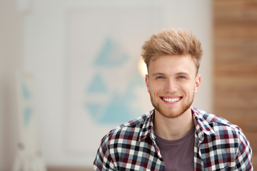 Portrait of handsome young man in room. Space for text