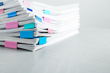 Stack of documents with binder clips on light table