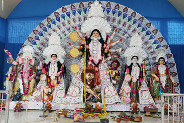 Goddess Durga idol at decorated Durga Puja pandal, shot at colored light, at Kolkata, West Bengal, India. Durga Puja is biggest religious festival of Hinduism and is now celebrated worldwide.
