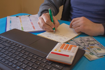 Fototapeta na wymiar man hand using pen for writing data information. A businessman doing some balance using his calculator