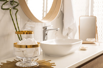 Obraz na płótnie Canvas Decorative jar with cotton pads on modern countertop in bathroom interior