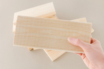 Woman holds a little plank in her hand.
