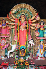 Goddess Durga idol at decorated Durga Puja pandal, shot at colored light, at Kolkata, West Bengal, India. Durga Puja is biggest religious festival of Hinduism and is now celebrated worldwide.