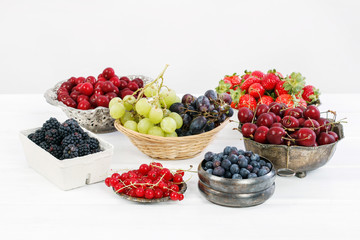 Various summer fruits on a white wooden table.