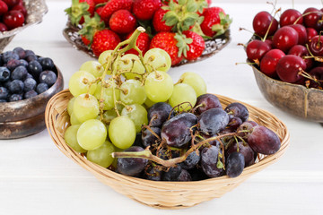 Various summer fruits on a white wooden table.