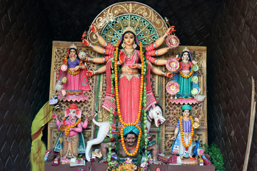 Goddess Durga idol at decorated Durga Puja pandal, shot at colored light, at Kolkata, West Bengal, India. Durga Puja is biggest religious festival of Hinduism and is now celebrated worldwide.