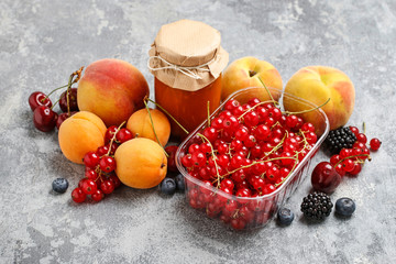 Redcurrant (ribes rubrum) in transparent box, peaches and cherries