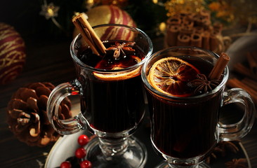 Christmas mulled vine with spices sinnamon stiks, anice stars, orange and New Year decorations on a wooden rustik table. Selective focus. Traditional hot drink at Xmas holiday