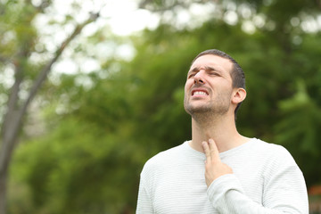 Man suffering throat ache complaining in a park
