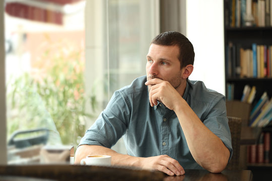 Pensive Man In A Coffee Shop Looking Through A Window