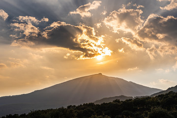 Sun hiding on a mountain