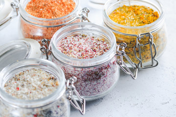 Four jars with different flavoured mixes of salt and spices. Himalayan and sea salt mixed with various peppers and herbs.