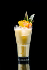 classic pina colada cocktail with reflection on dark background