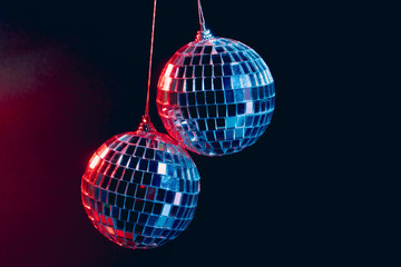 Sparkling disco balls hanging in the air against black background