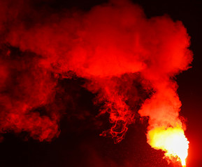 Red smoke burns at night as a background