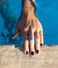 Manicure on the hands of a girl in the pool