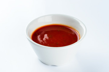 tomato ketchup sauce in a bowl on a light background