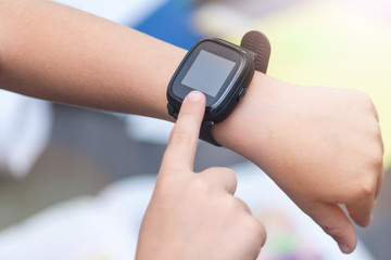 A close-up of child`s hands with smart watch. Touching electronic watch.