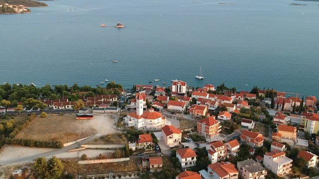 Church of Croatian Martyrs, Seget Vranjica, Croatia. Aerial Pull In, Hrvatskih mučenika church in a typical European town seafront. Drone fly over the city at golden hour. 