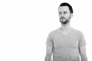 Studio shot of young man thinking while looking at distance