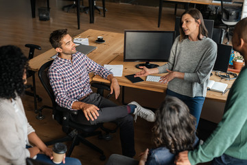 Diverse designers discussing a project together during an office meeting