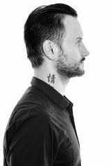 Portrait of man with neck tattoo with text meaning passion
