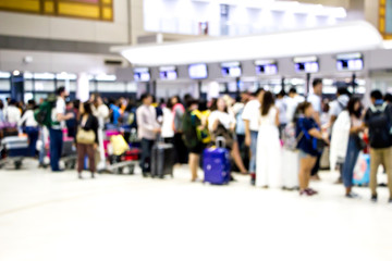 blurred passengers queuing at the airport