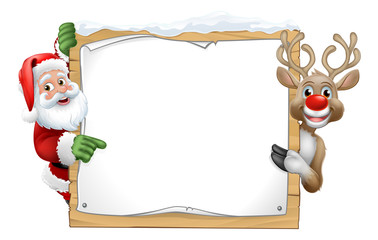 Santa Claus and Christmas reindeer cartoon characters peeking around a wooden sign and pointing at it - obrazy, fototapety, plakaty
