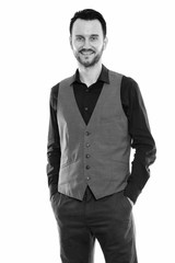 Studio shot of happy young man smiling while standing and wearing vest