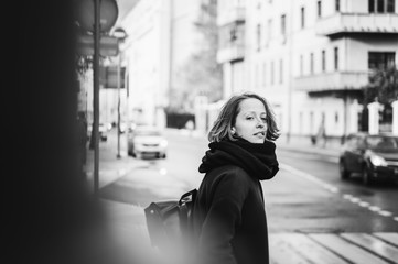 Young beautiful happy girl woman in a coat and scarf on a sunny autumn street