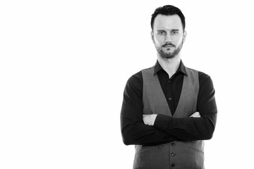 Studio shot of young man wearing vest with arms crossed
