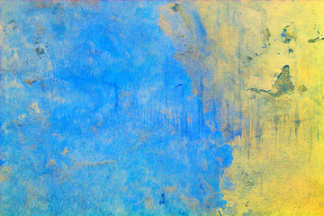 Background of the old concrete wall unevenly painted in the national colors of Ukraine - blue and yellow