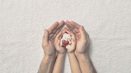 Hold hands of a child with a toy