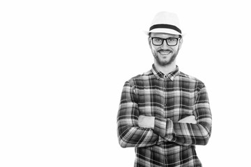 Studio shot of happy young man smiling with arms crossed