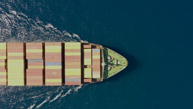 Luftaufnahme eines beladenen Container Schiffes in voller Fahrt &uuml;ber blauem Ozean