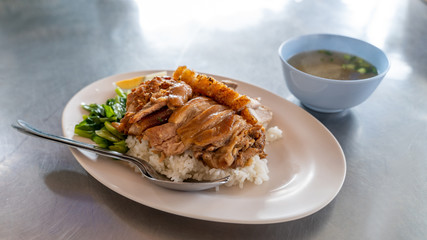 Stewed pork leg on rice and egg in a plate on a wooden table.Thaifood.