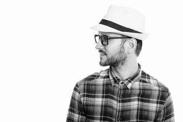 Profile view of happy young man smiling while wearing hat and eyeglasses