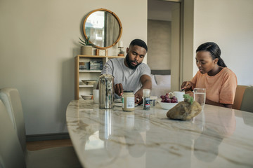 Young African American couple eating breakfast at their dining table