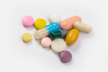 Assorted pharmaceutical medicine pills, tablets and capsules.Heap of assorted various medicine tablets and pills different colors on white background. Top view.Copy space