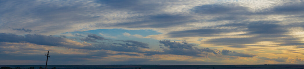 Leaden, storm clouds covered the sunset. Cumuliform cloudscape on blue sky. The terrain in southern Europe. Fantastic skies on the planet earth. Tragic gloomy sky.