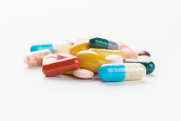 Assorted pharmaceutical medicine pills, tablets and capsules.Heap of assorted various medicine tablets and pills different colors on white background. Top view.Copy space