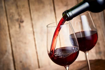 Fotobehang Rijke rode cabernetwijn die in een glas giet © exclusive-design