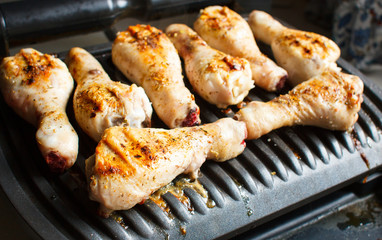 Marinated chicken legs fried on the hot flaming BBQ grill.