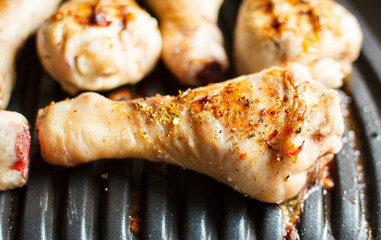 Marinated chicken legs fried on the hot flaming BBQ grill.