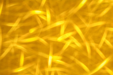 Abstract glitter golden glowing sparkling shiny background. Holiday gold wrapping paper texture. Christmas holiday seasonal wallpaper decoration. Greeting and wedding invitation card design template