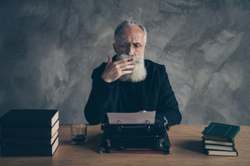 Portrait of his he nice attractive focused concentrated bearded gray-haired professional experienced publisher creating interesting life story novel over concrete wall background © deagreez