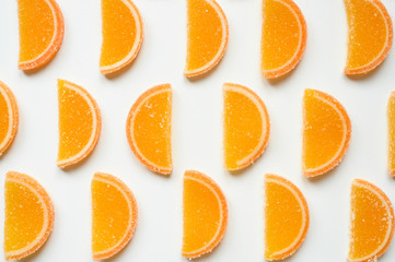 citrus jelly slices in sugar. marmalade slices of oranges and laid rows on a white background. top view