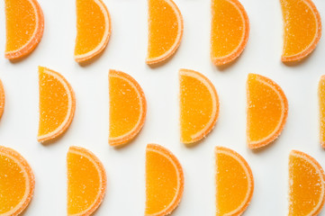 citrus jelly slices in sugar. marmalade slices of oranges and laid rows on a white background. top view