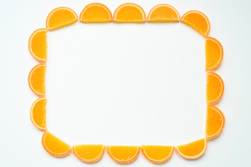 citrus jelly slices in sugar. marmalade slices of oranges, stacked frame on white background. top view